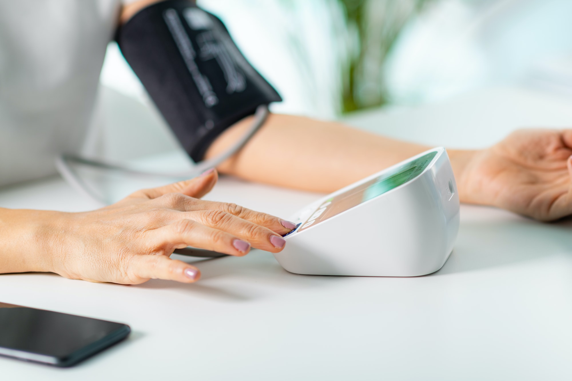 Senior checking blood pressure at home